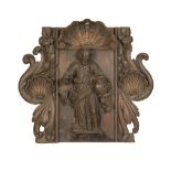 A carved oak figural plaque of a saint, possibly St James beneath a scallop shell probably 17th c...