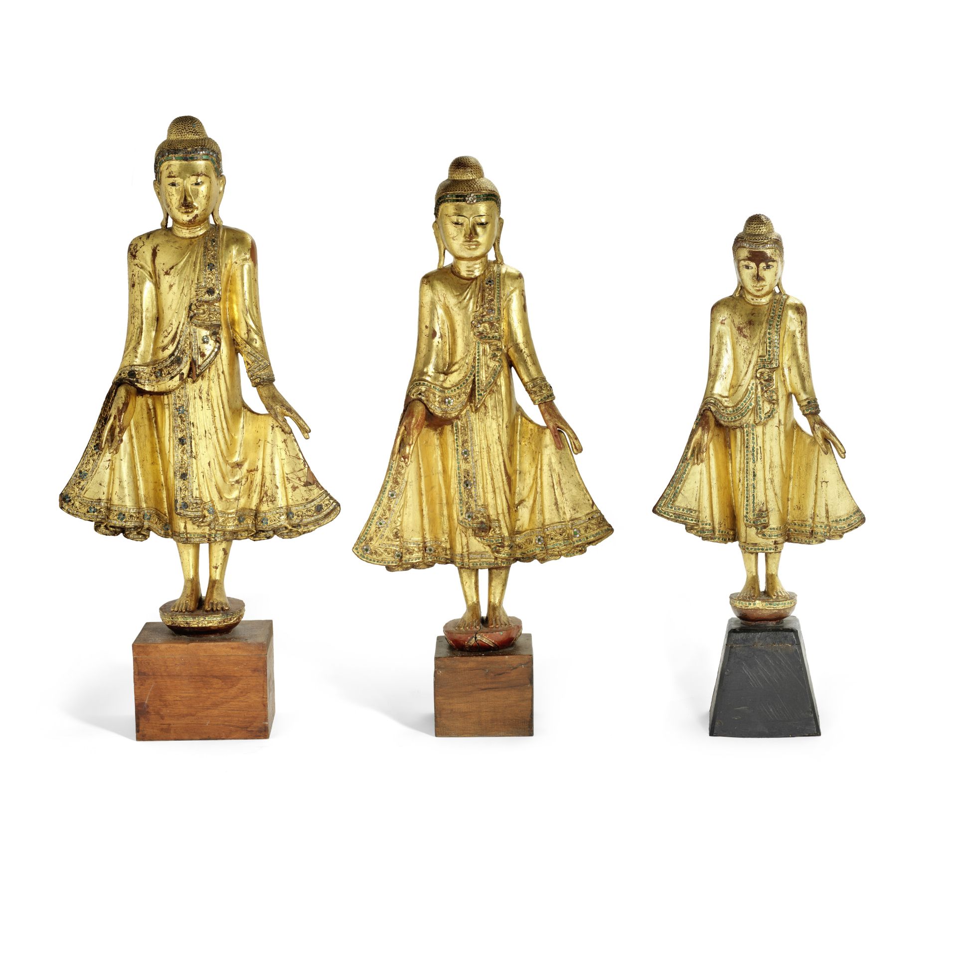 Three Burmese carved and giltwood standing figures of Buddha of varying sizes probably 19th / ea...