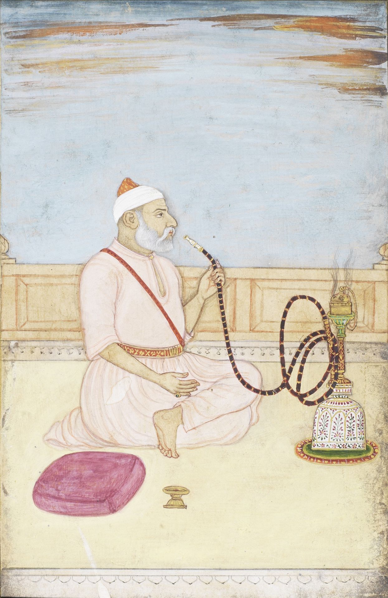 A man seated on a terrace smoking a hookah Mughal, 18th Century