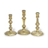 Three Queen Anne/George I brass alloy octagonal-based socket candlesticks, circa 1715 (3)