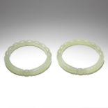 A PAIR OF PALE JADE 'CONFRONTING DRAGONS' BANGLES