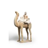 A LARGE PAINTED POTTERY MODEL OF A CAMEL WITH A 'FOREIGNER' RIDER Tang Dynasty