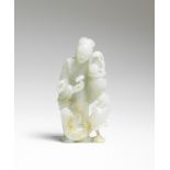 A PALE GREEN AND RUSSET JADE FIGURE OF MAGU 18th century