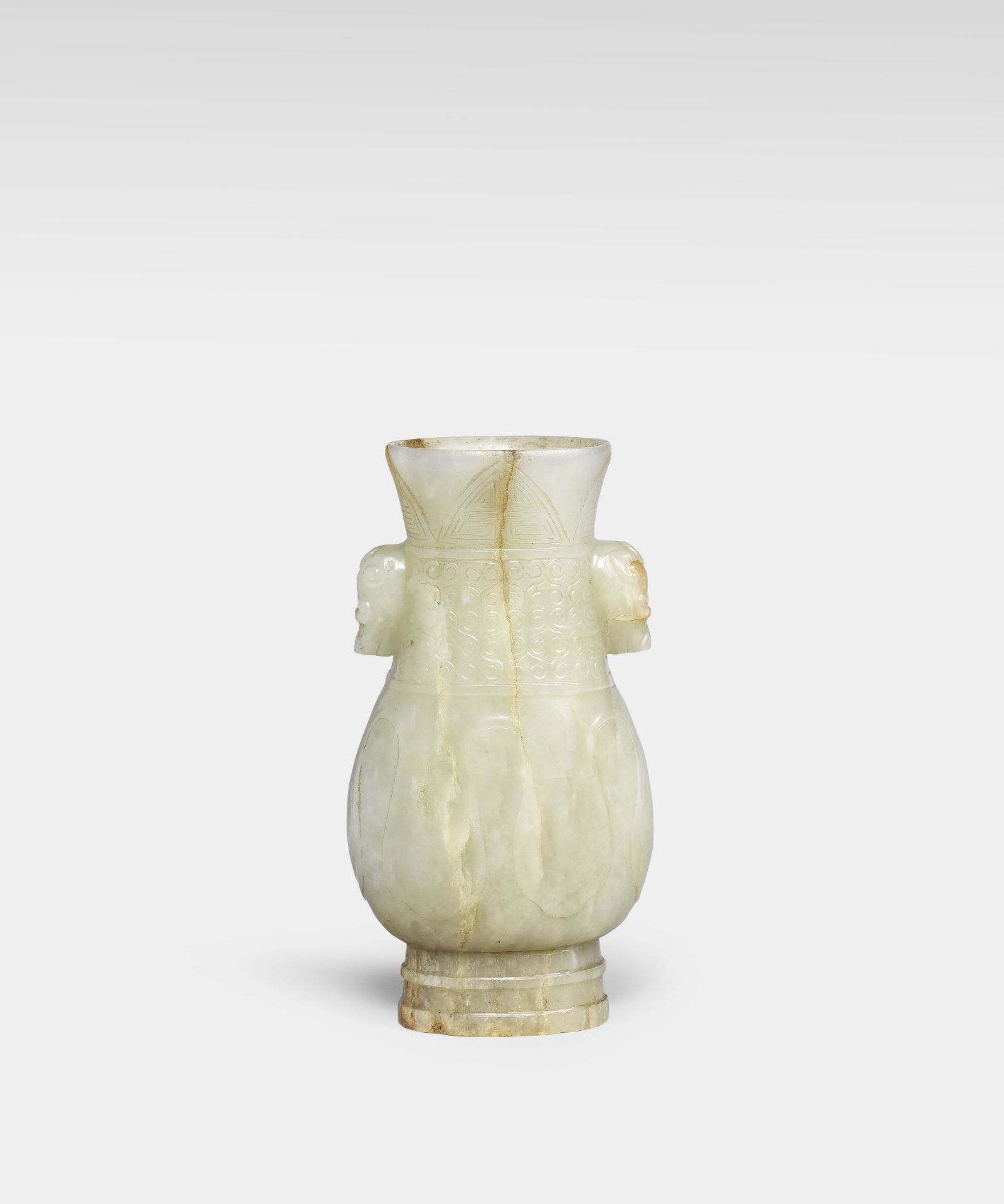 AN ARCHAISTIC PALE GREEN AND RUSSET JADE VASE, HU Yuan/Ming Dynasty