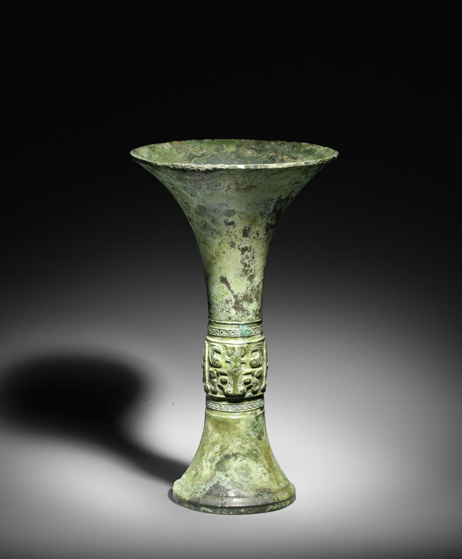 A VERY RARE ARCHAIC BRONZE RITUAL WINE VESSEL, GU Late Shang Dynasty