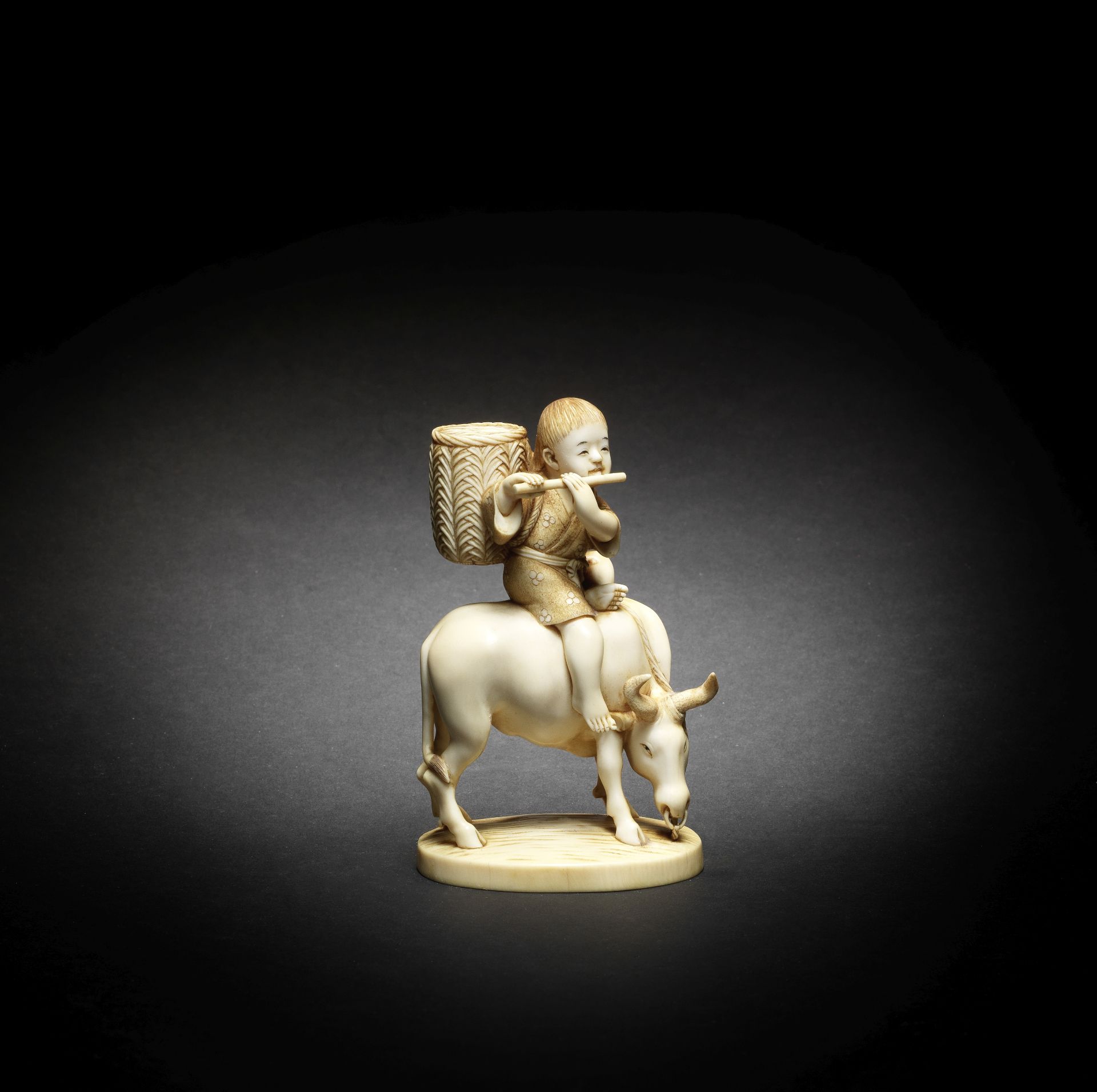 An ivory okimono of a boy on an ox By Hozan, Meiji era (1868-1912), late 19th/early 20th century