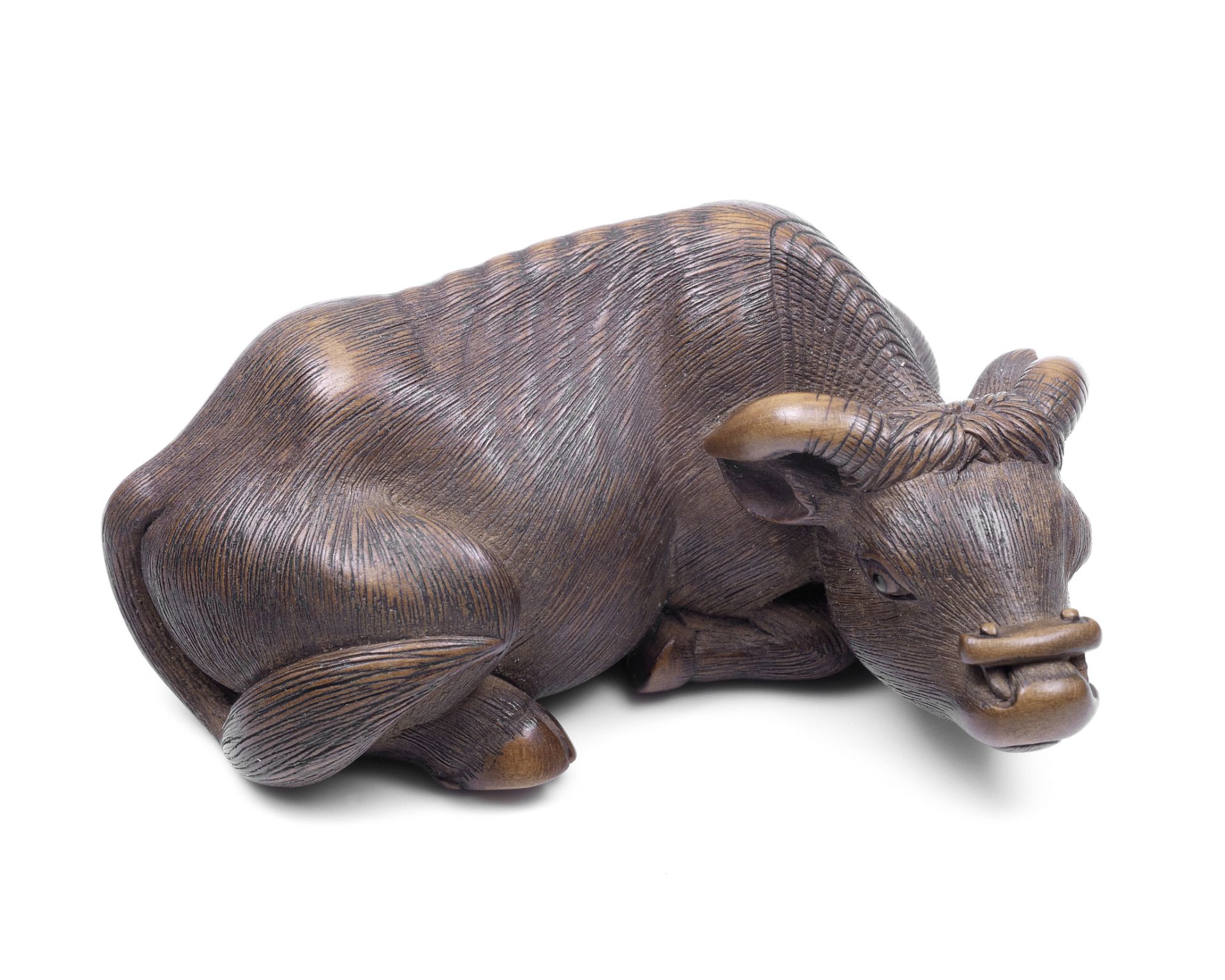 A wood netsuke of a recumbent ox By Masanao, Kyoto, Edo period (1615-1868), late 18th century