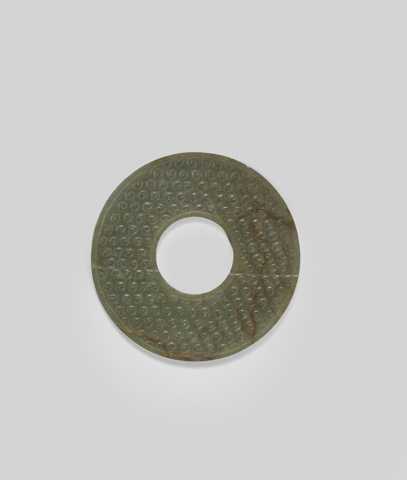 AN ARCHAIC GREEN AND RUSSET JADE DISC, BI Warring States Period/Han Dynasty