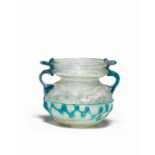 A Roman pale green glass jar with turquoise twin handles