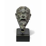 A Roman bronze lamp in the form of the head of a satyr