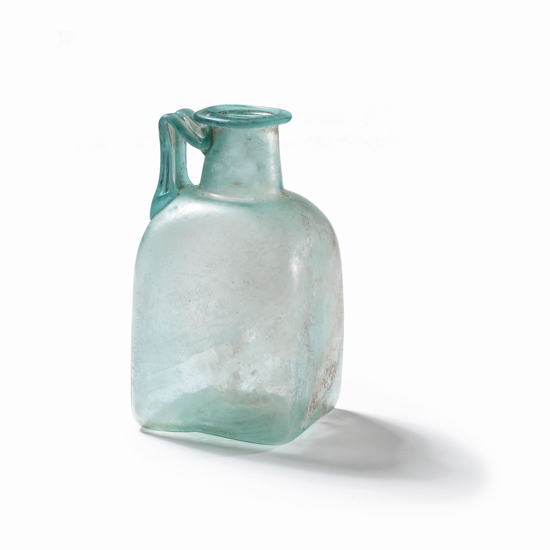 A Roman pale blue square glass jug