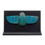 An Egyptian turquoise glazed composition winged scarab appliqu&#233;