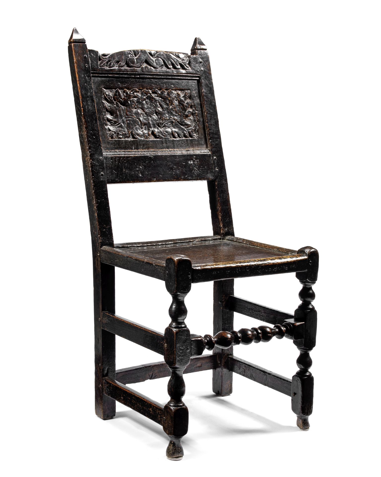 A 17th century carved oak panel back stool