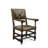 A 17th century oak and leather brass close nailed upholstered armchair
