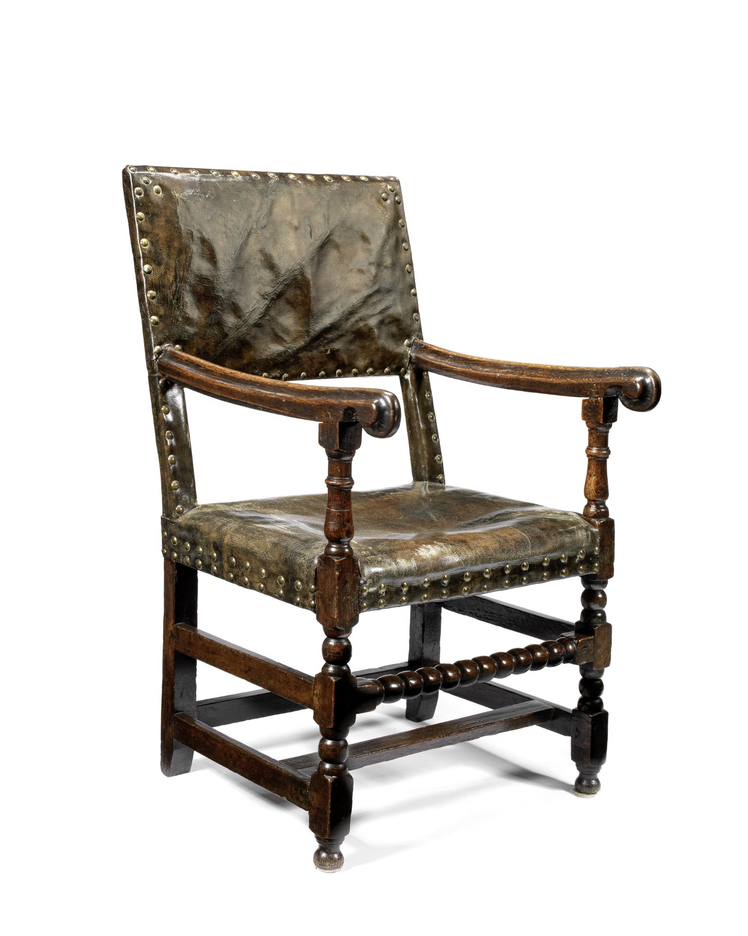 A 17th century oak and leather brass close nailed upholstered armchair