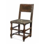 A mid-17th century oak and leather upholstered chair