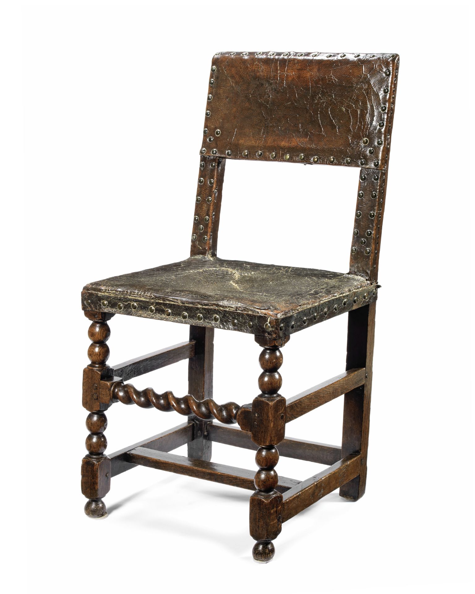 A mid-17th century oak and leather upholstered chair