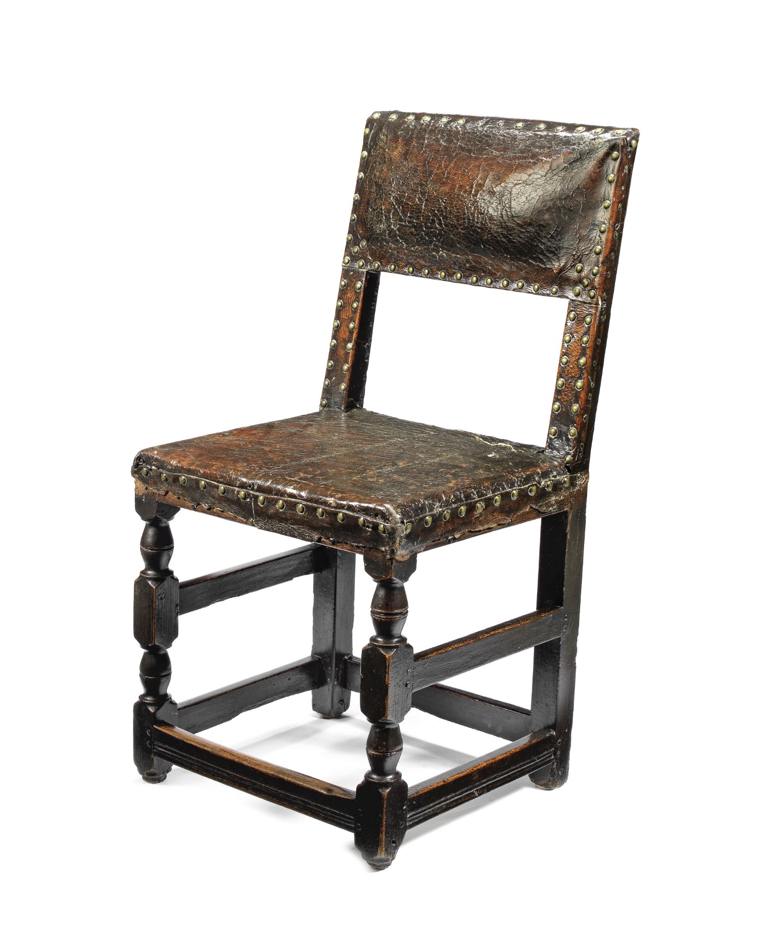 A mid-17th century oak and leather upholstered chair