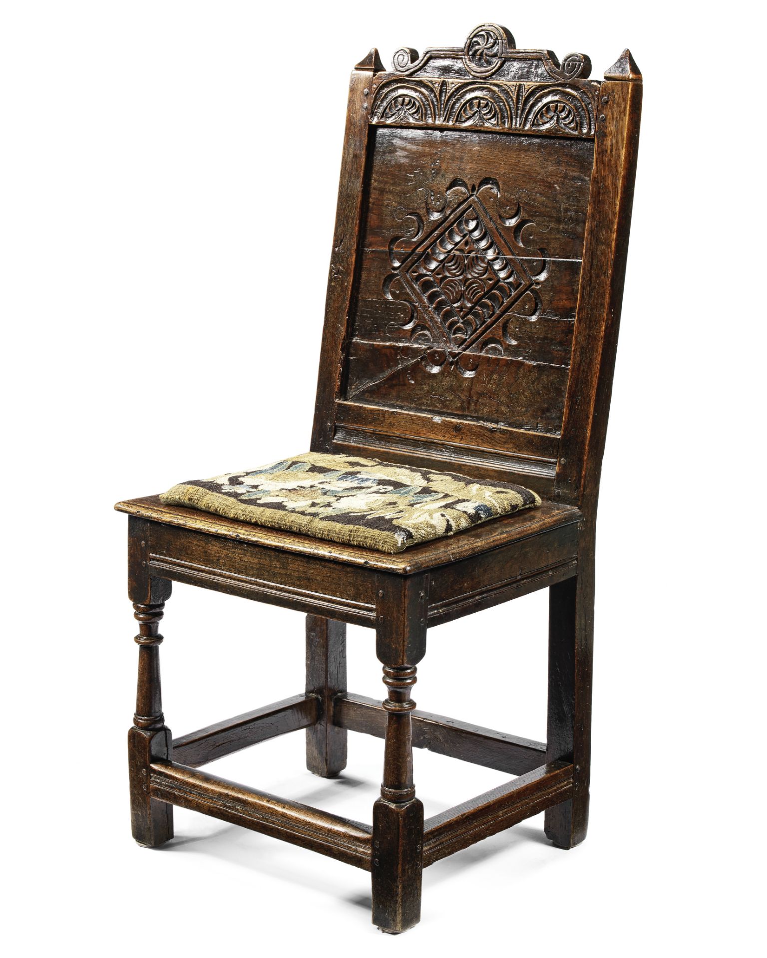 A 17th century carved oak panel back stool