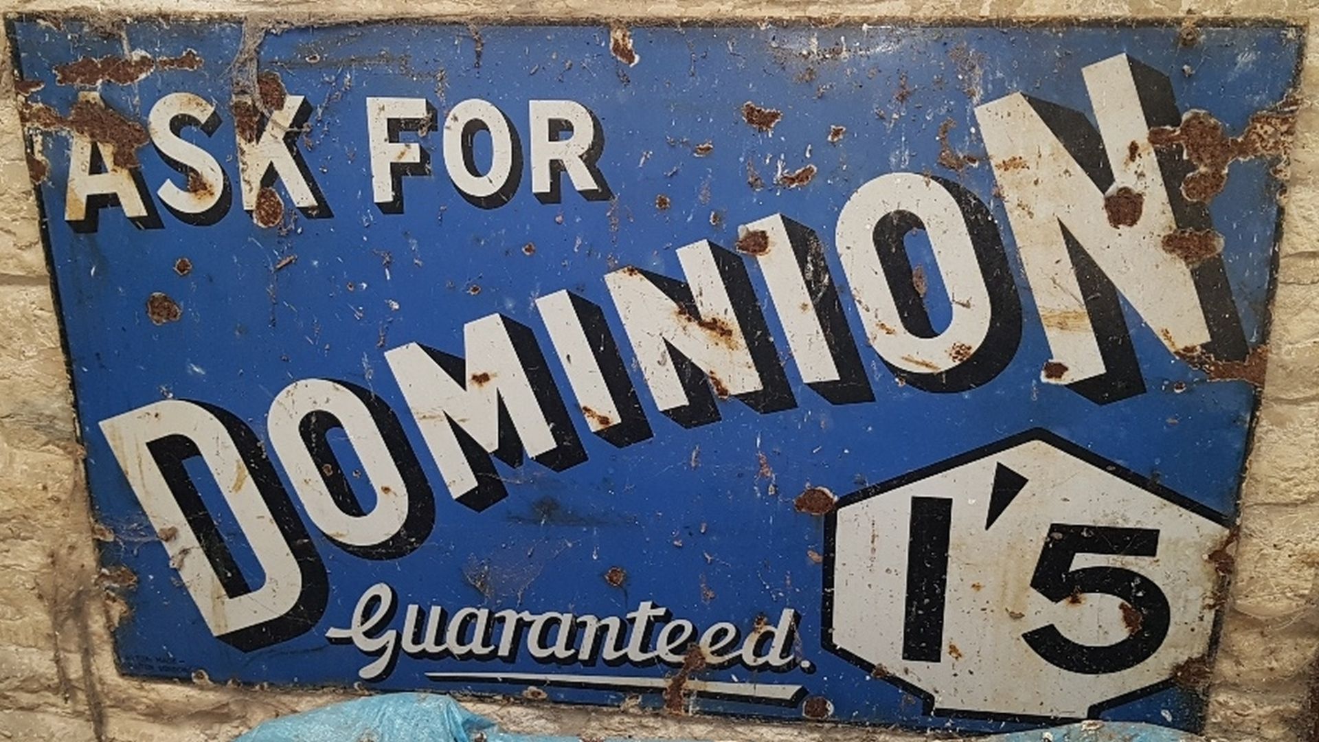 An 'Ask for Dominion Guaranteed' enamel sign,