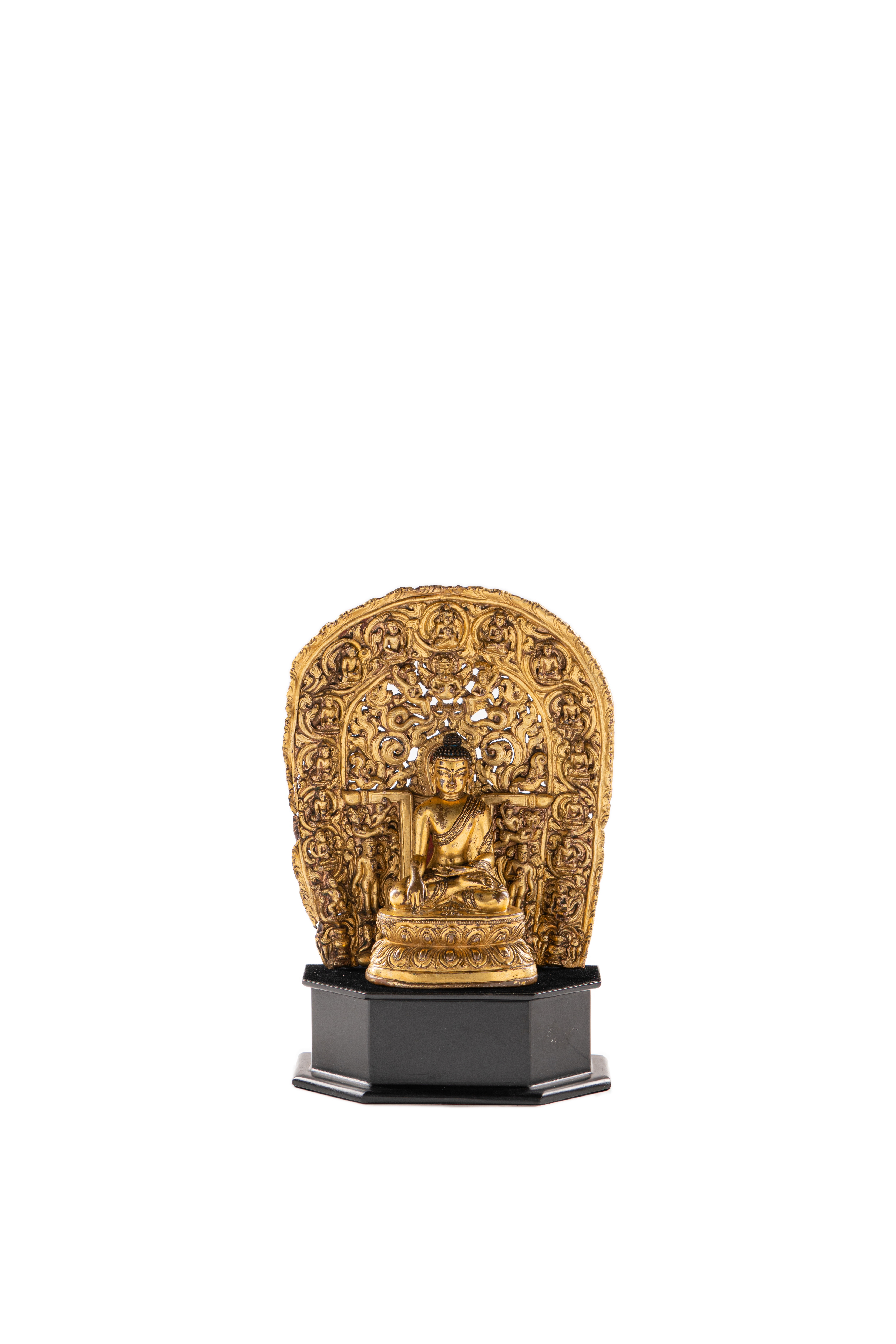 A GILT COPPER-ALLOY FIGURE OF BUDDHA, TOGETHER WITH AN ASSOCIATED MANDORLA Tibet, 15th/16th centu...