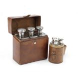 A leather-cased set of three glass drinks flask with sterling silver caps, retailed by Asprey of ...