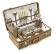 A wicker-cased 'Coracle' picnic set for four persons by G W Scott & Sons, circa 1909,