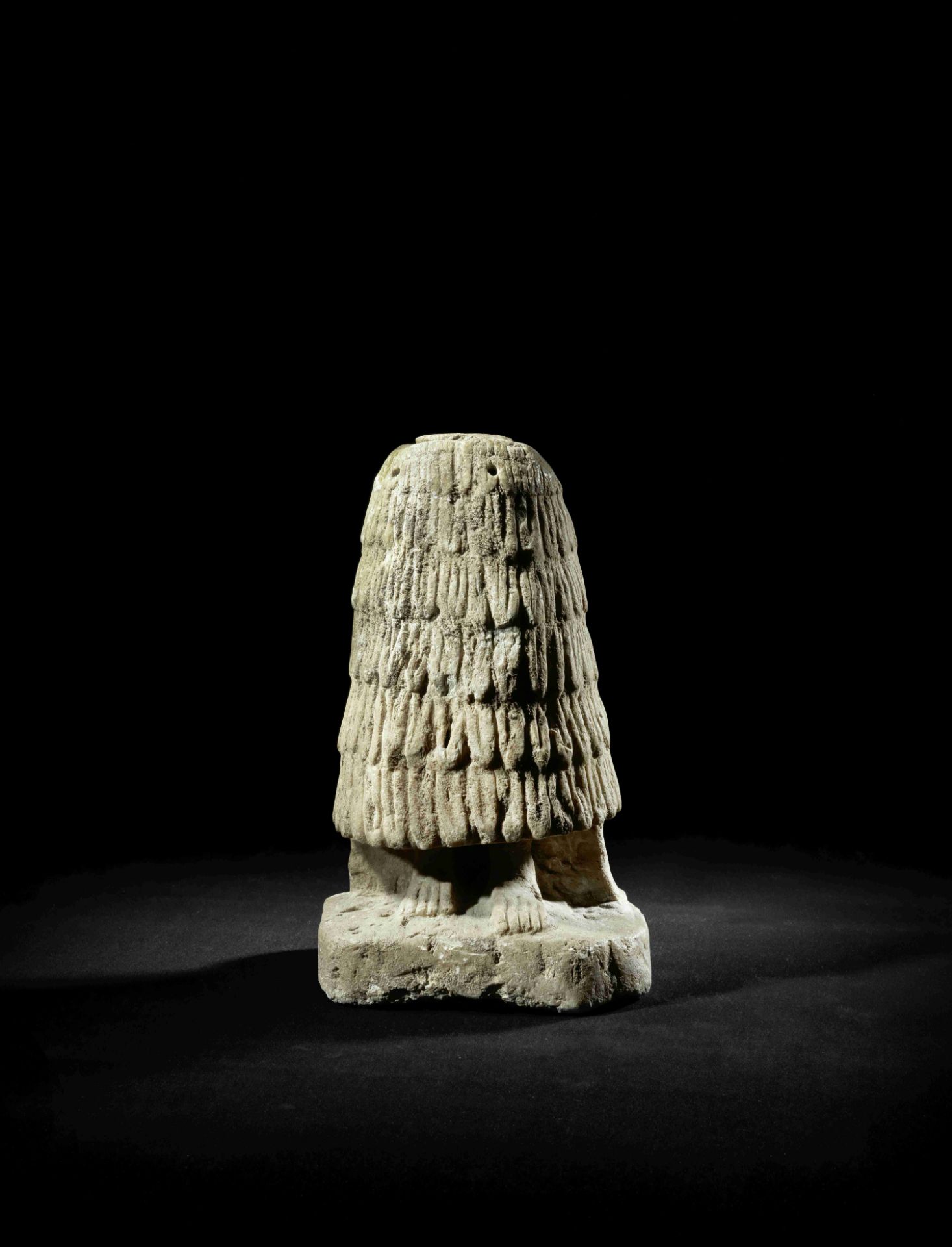 The lower portion of a large Sumerian limestone worshipper figure