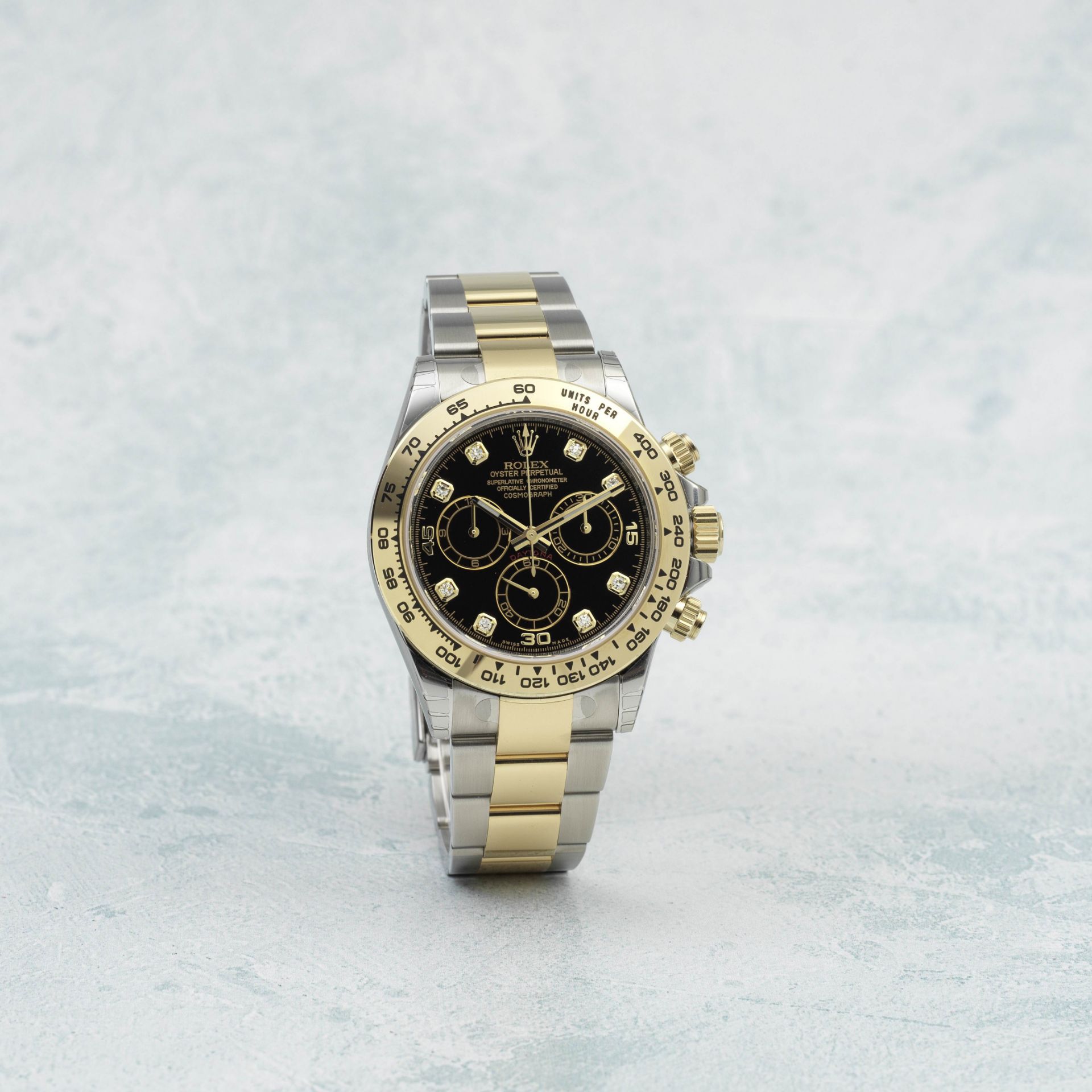 Rolex. A fine 18K gold and stainless steel automatic chronograph bracelet watch with diamond set ...