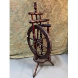 An Antique dark wood spinning wheel sat upon three legs. [Signs of old woodworm]