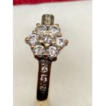 A 9ct gold diamond flower head design ring. [0.33cts] [Ring size L]
