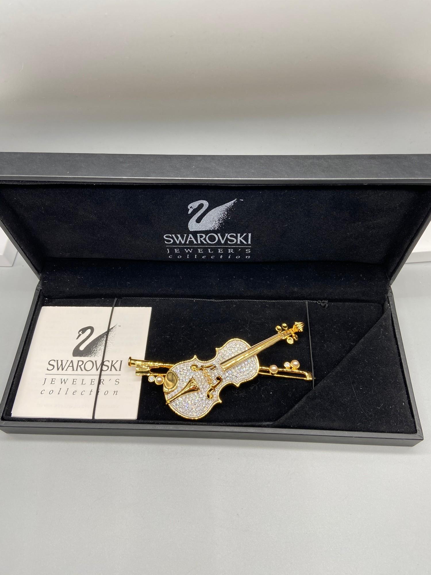 A Lovely example of a Swarovski brooch in the shape of a violin and bow. Comes with a box.