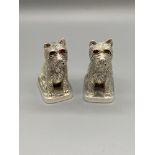 A Pair of silver plated condiment pots in the form of highland terriers. [5.6cm in height]