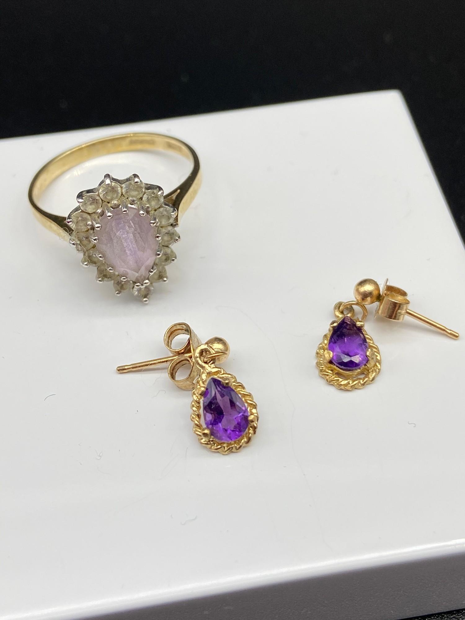 A 9ct gold ladies ring set with a pale purple tear drop stone surrounded by clear stones, Together