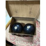 Two antique wooden bowling bowls with ivory inserts. Comes with small carry case.