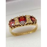 A Lovely example of a ladies 18ct gold ring set with three large garnets and 4 small diamonds. [Ring