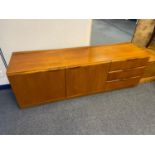 A Mid century teak sideboard designed with two doors and three drawers. Nice clean condition.