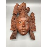 A Chinese hard wood hand carved wall mask detailed with a dragon and phoenix to each part of the