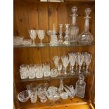 Three shelves of crystal whisky, wine glasses. To include decanters, Bell and candle sticks etc
