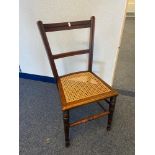 Antique farmhouse chair designed on turned leg supports and bergere seat area.