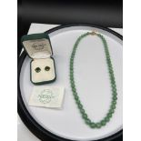 A Vintage jade graduating bead necklace together with a pair of green jade earrings.