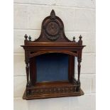 A 19th century dark wood wall shelving unit. designed with a carved lady portrait/ silhouette to the