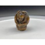A Japanese hand carved netsuke of an older gentleman carrying fish on his back. Signed to the base.
