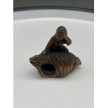 A Japanese hand carved netsuke of a mermaid sat upon a large shell. Signed. [4.5cm in length]