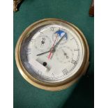 An Antique brass cased Smith Enfield 8 day ship clock with moon dial design. [20cm in diameter]