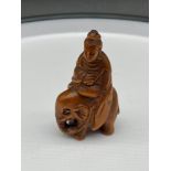 A Japanese hand carved netsuke of a Thai god figure riding an elephant. Signed. [5.5cm in height]