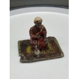An Austrian Bergman cold painted bronze gentleman seated on a rug smoking an opium pipe. [6cm in