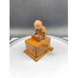 A c1930's Japanese Kobi Toy of a figure eating watermelon. Signed to the side. Also has a label to