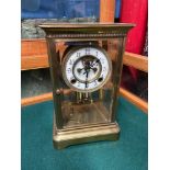 An Antique Brass cased and bevel edge glass clock. Designed with a mercury, glass and brass