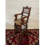 A 19th century child's high chair, which converts to a rocker. Made from wood and mechanical